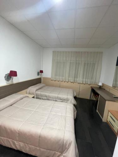 a room with two beds and a desk in it at Hotel Ibi in Ibi