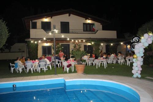 a group of people sitting at a table in front of a house at Appartamento VILLA ADRY in Rome