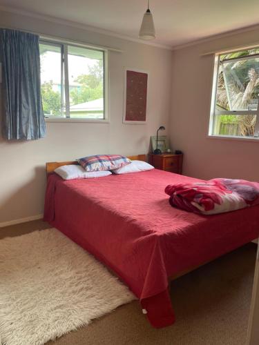 1 dormitorio con 1 cama con manta roja en Classic Kiwana Batch en Purau