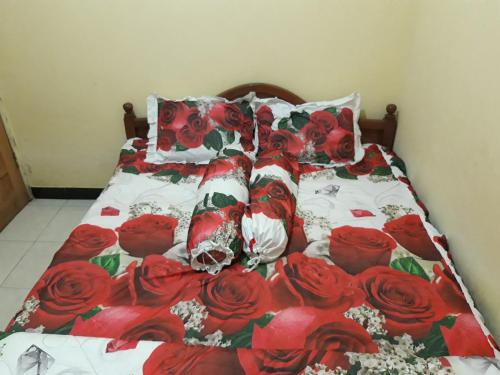 a bed with red roses on it at OYO Homes 91083 Desa Wisata Plosokuning Syariah in Soprayan