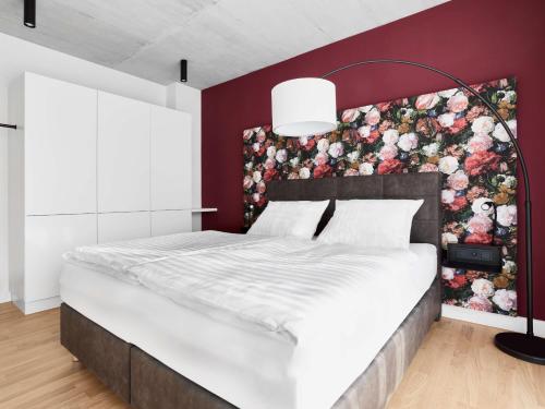 a bedroom with a large bed with a floral wall at livisit bergapartments in Stuttgart
