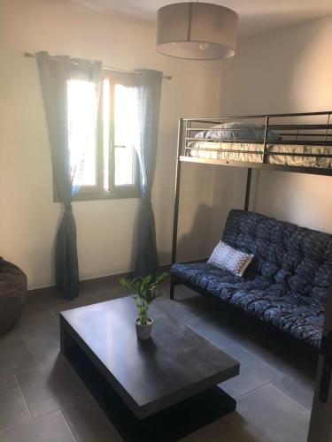 a living room with a couch and a bunk bed at Haut de Villa - Vue mer avec Coucher de Soleil in Cargèse