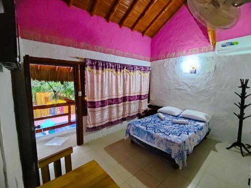 ein Schlafzimmer mit einem Bett in einem Zimmer mit rosa Wänden in der Unterkunft Casa Del Merman at GayMontanita House in Montañita