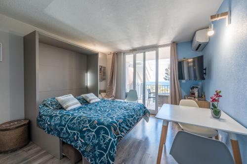 a bedroom with a bed and a table and a desk at Studio *** "ThalaBanyuls" - Vue mer - Balcon in Banyuls-sur-Mer