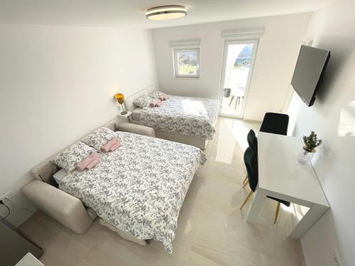 an overhead view of a bedroom with two beds and a desk at Apartment Vila ** in Stinica