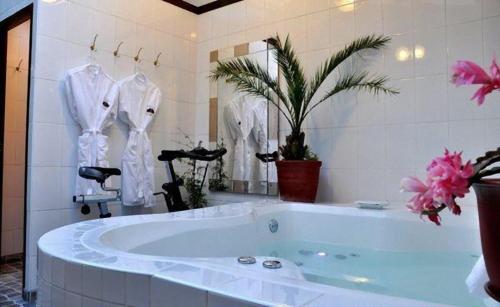 bagno con vasca e accappatoi bianchi in esposizione di Hotel Rumi Punku a Cuzco
