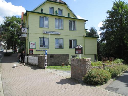a person riding a skateboard in front of a yellow building at Pension Parkblick in Braunlage