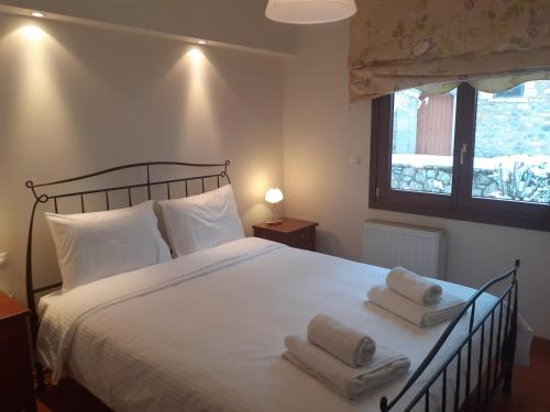 una camera da letto con un letto con due asciugamani sopra di Family's Houses a Kalavrita