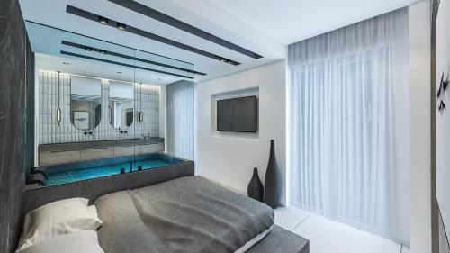 a bedroom with a tub and a bed and a television at Hotel Papagalos in Neos Marmaras