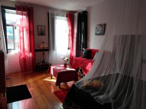 a bedroom with red curtains and a bed and a window at AL- Almada 4 in Porto
