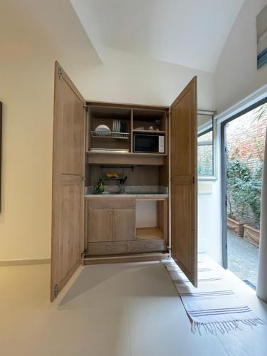a kitchen with a wooden cabinet with a microwave at La Casa di Greta in Camogli