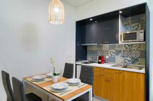 a kitchen with a table with chairs and a microwave at Encanto Village -Apartments in Potos