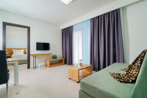 a hotel room with a couch and a bedroom at Encanto Village -Apartments in Potos