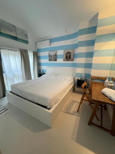 a bedroom with a bed with blue and white stripes at La Casa di Greta in Camogli