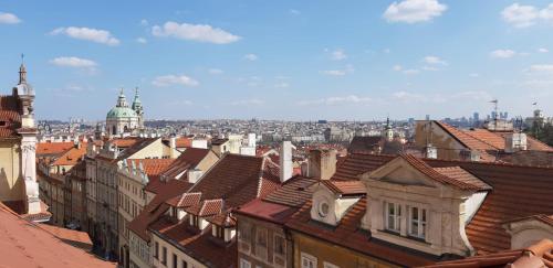 Blick auf eine Stadt mit Dächern von Gebäuden in der Unterkunft The Golden Wheel Hotel in Prag