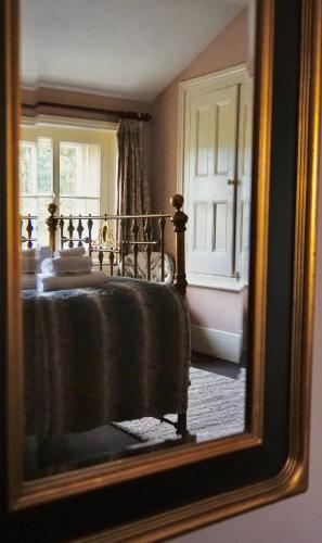 a reflection of a bedroom with a bed in a mirror at Derby Arms Witherslack in Grange Over Sands