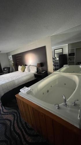 a hotel room with a bath tub and a bed at Country Town N' Suites in Gatlinburg