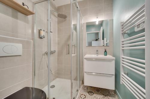 a bathroom with a shower and a toilet and a sink at Le studio d'Angèle in Bruz