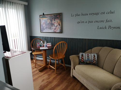 a living room with a couch and a table at Les Cabines du Phare in Rimouski