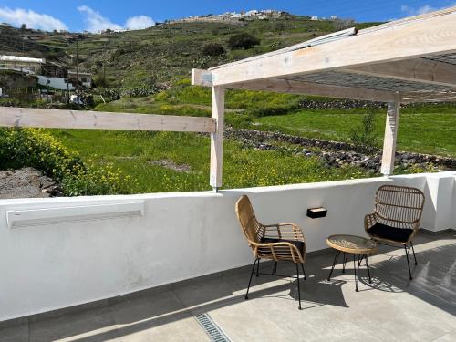 two chairs and a table on a porch with a view at Episkopi Estate Cycladic Villas in Éxo Goniá
