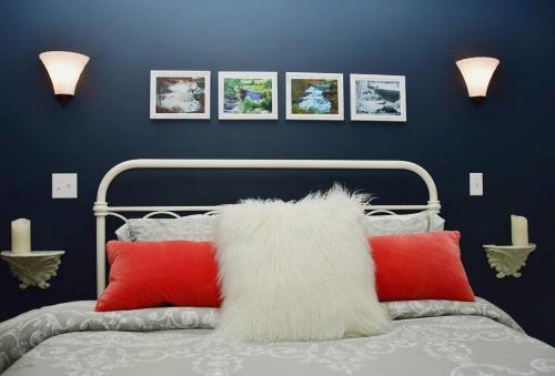 een slaapkamer met een bed met rode en witte kussens bij Cottage at Millpond Falls - A Romantic Escape in Warwick