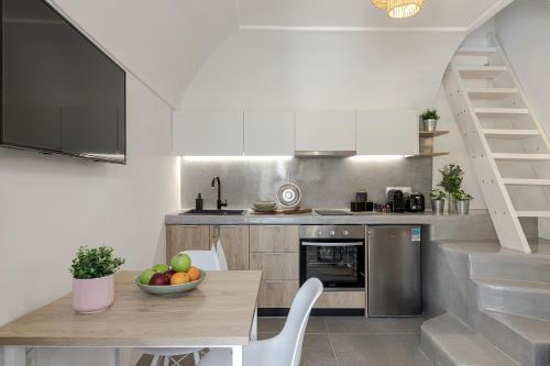 a kitchen with a table with a bowl of fruit on it at Episkopi Estate Cycladic Villas in Éxo Goniá