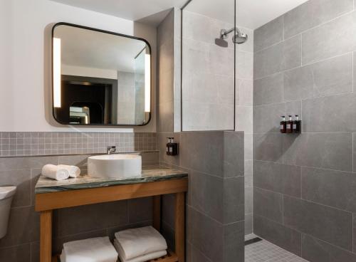 a bathroom with a sink and a mirror at Kissel Uptown Oakland, in the Unbound Collection by Hyatt in Oakland
