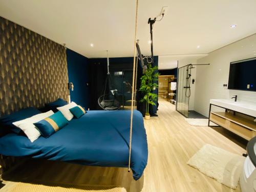 a bedroom with a swing bed and a bathroom at Capsule Temps suspendu - balnéo, home cinema & billard in Valenciennes