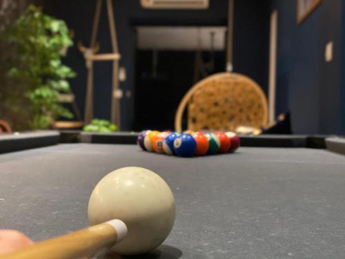 a person holding a pool cuehibahiba at Capsule Temps suspendu - balnéo, home cinema & billard in Valenciennes