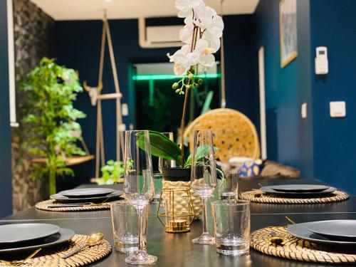 a table with plates and glasses on a table at Capsule Temps suspendu - balnéo, home cinema & billard in Valenciennes