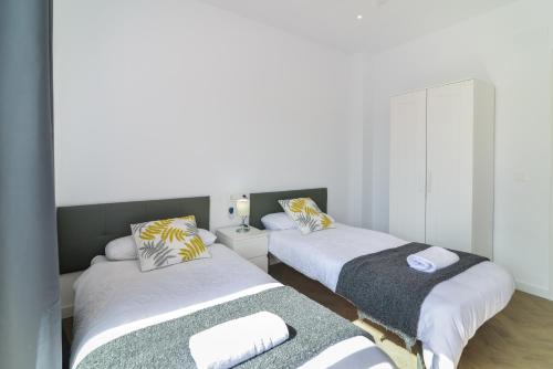 two beds in a room with white walls at LXR Bellavista 3Hab. Next to Sea in Fuengirola
