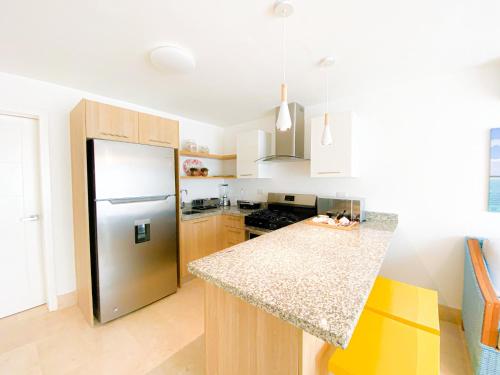 a kitchen with a stainless steel refrigerator and a counter at Xeliter Green One Playa Dorada in San Felipe de Puerto Plata
