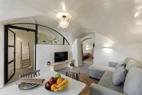 a living room with a couch and a table with fruit at Episkopi Estate Cycladic Villas in Éxo Goniá