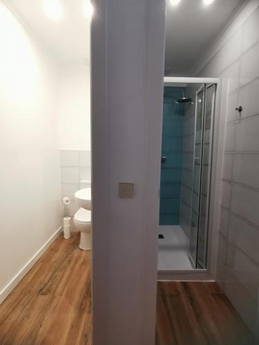 a white bathroom with a shower and a toilet at Castilho 63 Hostel & Suites in Lisbon