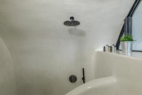 a bathroom with a shower with a tub and a sink at Episkopi Estate Cycladic Villas in Éxo Goniá