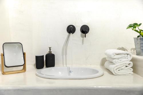 a bathroom counter with a sink and towels at Episkopi Estate Cycladic Villas in Éxo Goniá