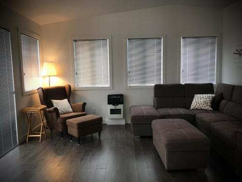 a living room with a couch and chairs and windows at Domaine Gagnon in Saint Sebastien