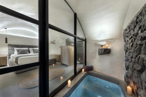 a bedroom with a bed and a tub in a room at Episkopi Estate Cycladic Villas in Éxo Goniá