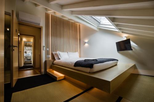 a bedroom with a bed and a skylight at Viseu Ryokan ヴィゼウ 旅館 - Hospedaria Japonesa & SPA in Viseu