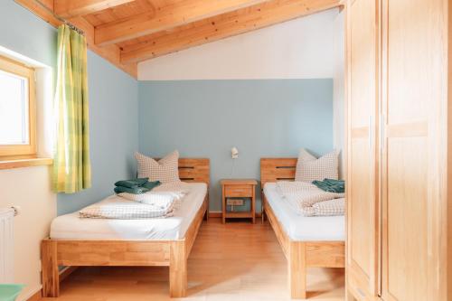 two beds in a room with wooden floors at Reiterhof Berggut Gaicht in Nesselwängle