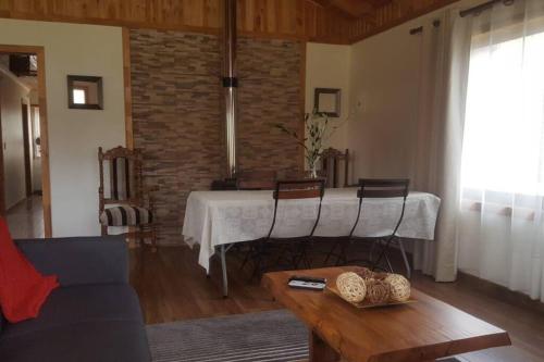 普孔的住宿－Tranquilidad y descanso en Villarrica - Pucón，客厅配有桌椅和沙发