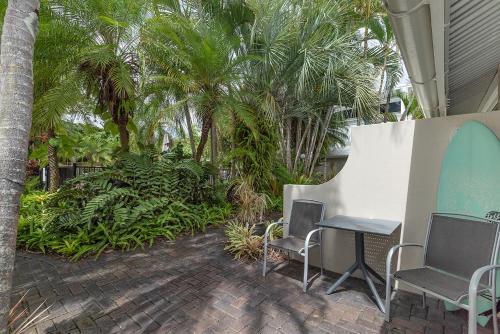 a patio area with chairs, a bench, and an umbrella at Caribbean Noosa in Noosa Heads