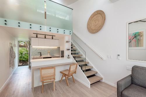 a staircase leading up to a living room with a sink and a living room with at Caribbean Noosa in Noosa Heads