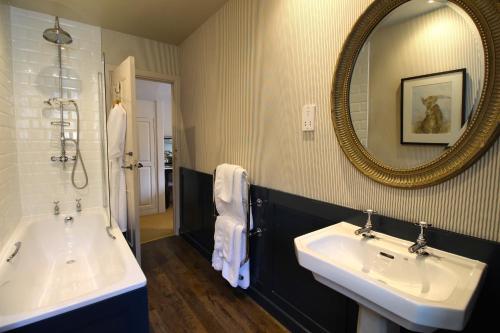 ein Badezimmer mit zwei Waschbecken und einem Spiegel in der Unterkunft The Hare & Hounds Hotel in Tetbury