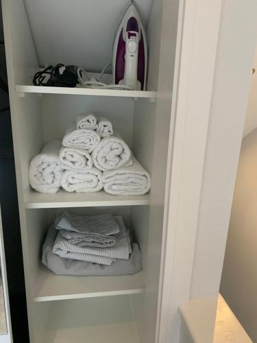 a closet with towels and a pile of towels at Cosy Beautiful One bedroom Flat in Dorking