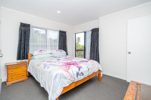 a bedroom with a bed and a window at Family Home on Robert St in Raglan