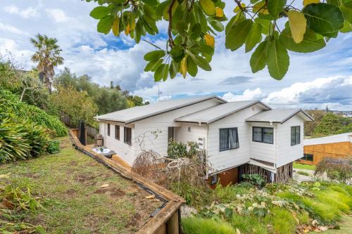 a white house with a roof at Family Home on Robert St in Raglan
