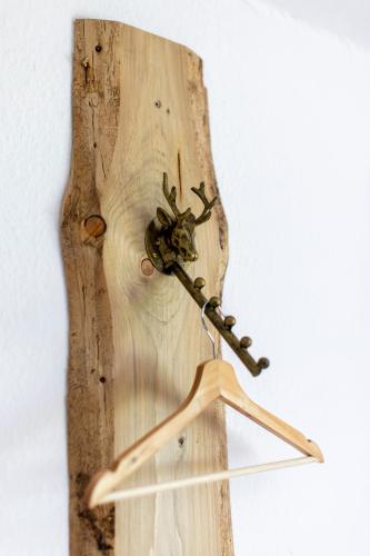 a wooden hanger with a clock on a wall at Bergische Schweiz in Engelskirchen