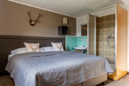 a bedroom with a large bed and a bathroom at Bergische Schweiz in Engelskirchen
