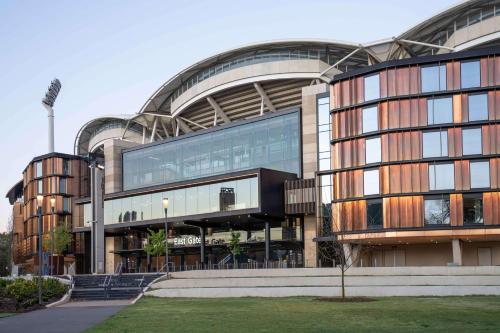 a large building with a large glass facade at Oval Hotel at Adelaide Oval in Adelaide